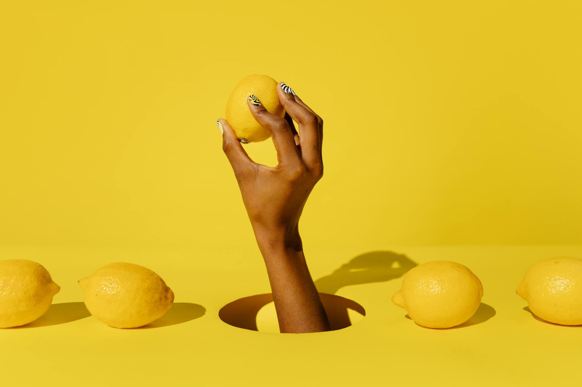 A hand holding a lemon against a vivid yellow background, symbolizing fresh sensitivity and arousal timing