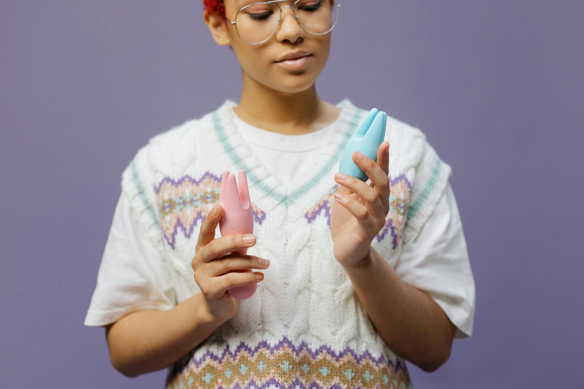 Woman holding lemon clitoral vibrator with thoughtful expression