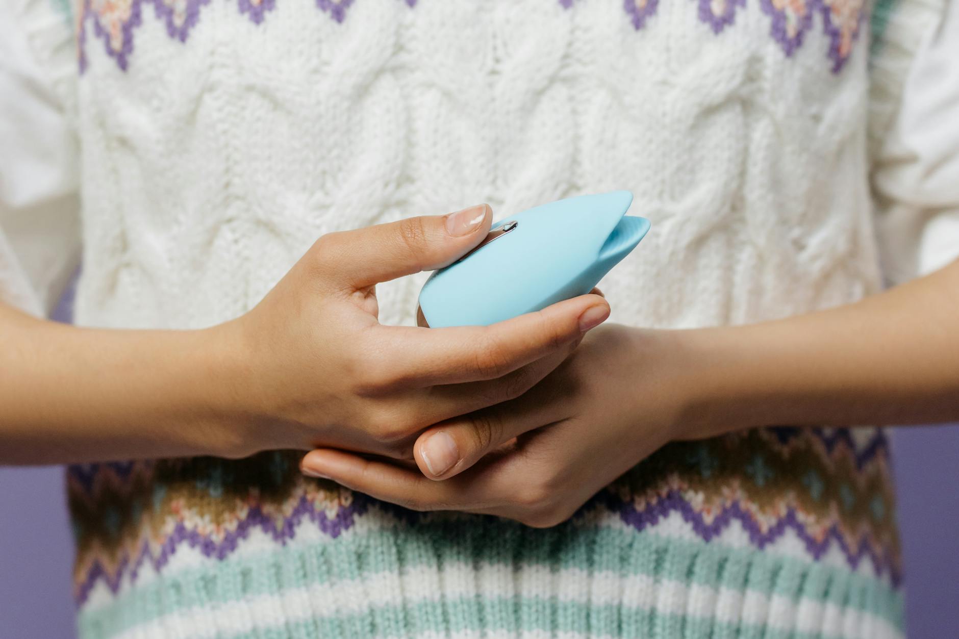 A blue silicone vibrator held in hand, representing solo and partnered pleasure.